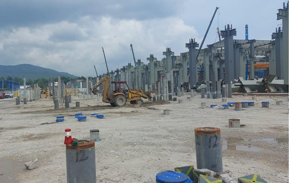 Piling works with crane and concrete piles at an industrial site