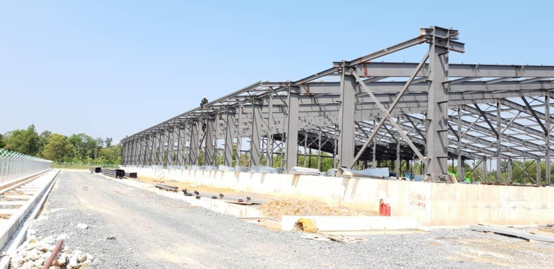 Wide-angle view of a steel warehouse frame under construction at CJ Bio Paka, dramatic perspective